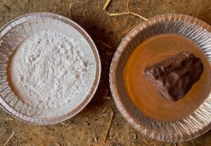 a pan of baking soda sits next to a pan containing a small block of goat mineral. 